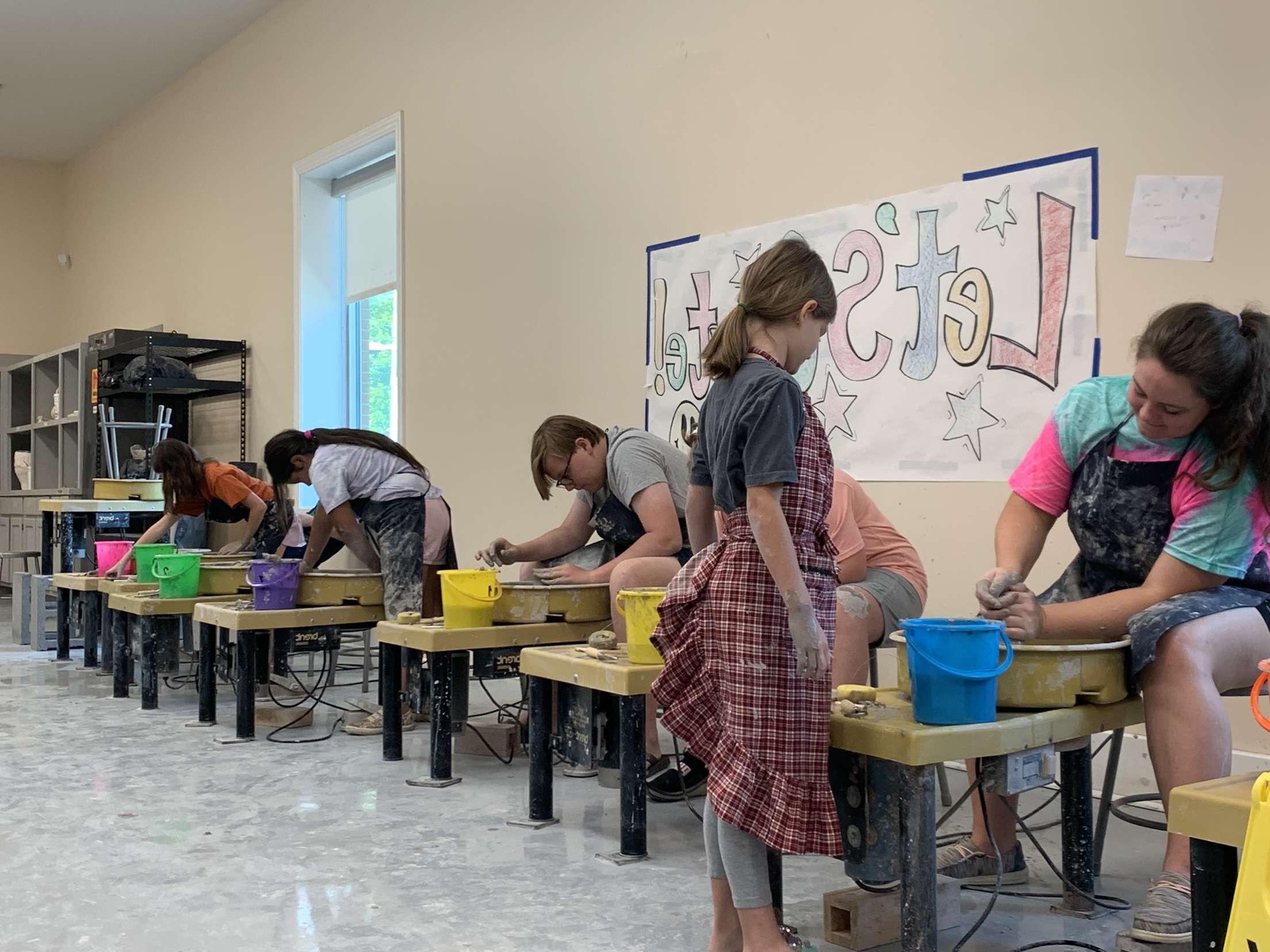 Clay pots for kids participants using the pottery wheels all in a line. 